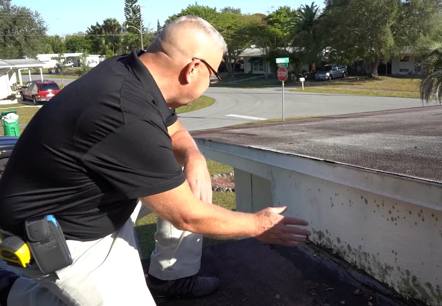 Michael Vecchione checking the edge of a roof during an inspection