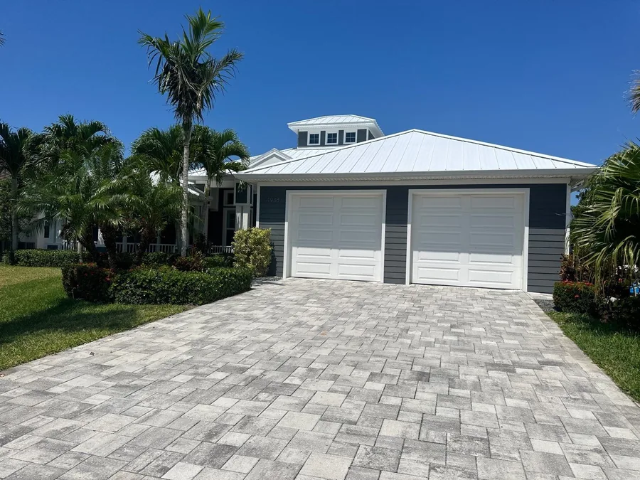White metal roof on a home with a paver driveway