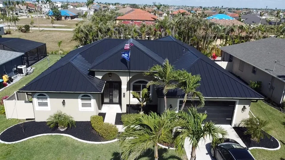 Black standing-seam metal roof on a home with a flag out front