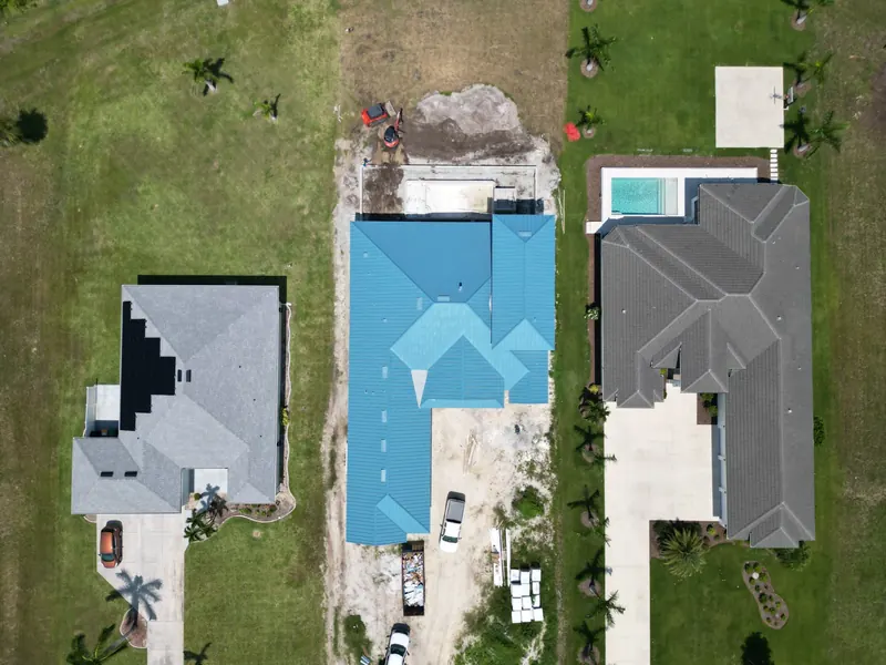Blue metal roof between neighboring homes, seen from above