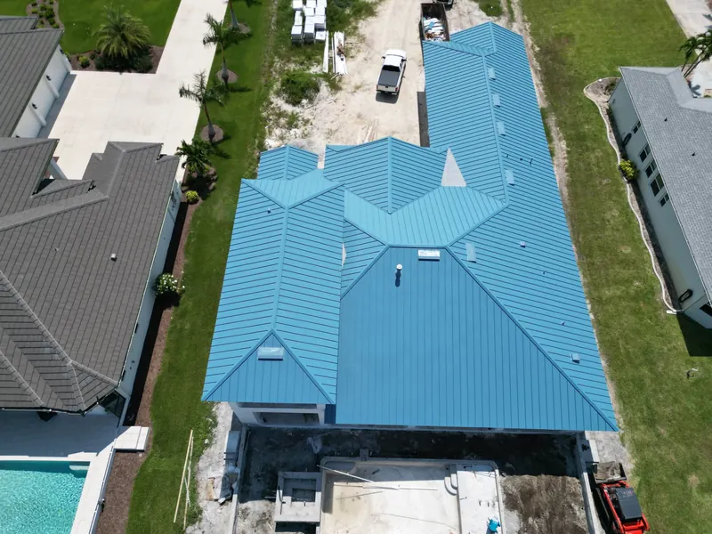 Top-down view of a long house with a blue metal roof