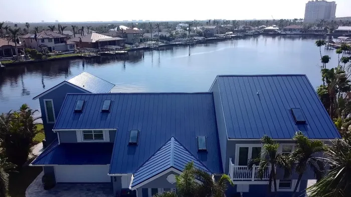 A blue standing-seam metal roof on a canal home